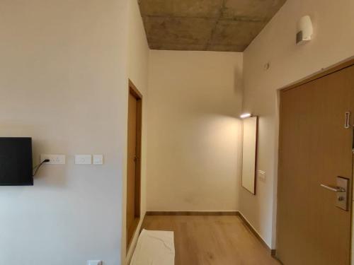 an empty hallway with a door and a television at Zostay Urban Retreat Deluxe Rooms & Premium Dorms in Manjeri