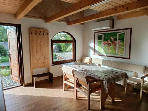 a dining room with a table and a window at Domki Nad Bocianim Gniazdem in Bukowiec