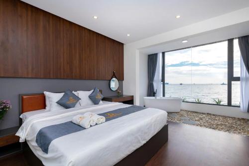 a bedroom with a large bed with a tub and a window at Villas VIP Trực Diện View Biển GREEN DAY 24 Sang Trọng in Vung Tau