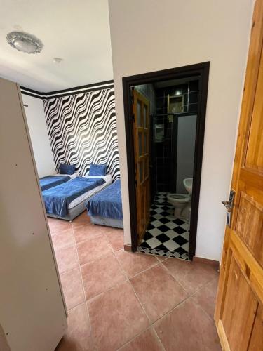 a bedroom with two beds and a doorway at BananaHouse in Tamri