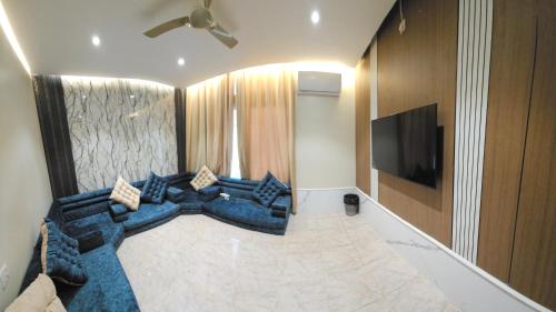 a living room with a blue couch and a flat screen tv at فندق سماء الإمارات in Khawr Maksar