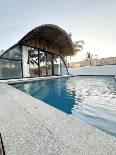 a swimming pool in front of a building at Bukit Langit Campventure in Glagah