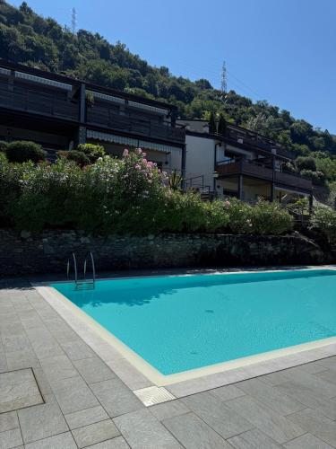 a blue swimming pool in front of a building at Bluelow Lakeview house in Dervio