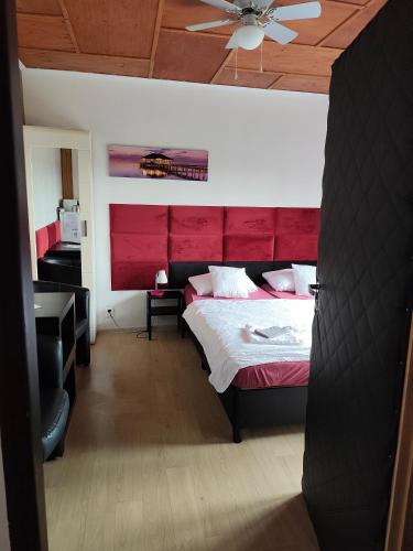 a bedroom with a large bed with a red headboard at Penzion U Ježů - Ubytování in Pasohlávky