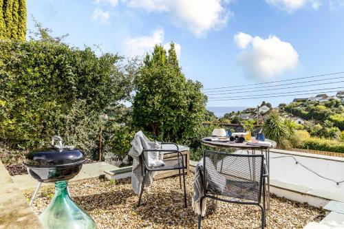 a patio with a grill and a table and chairs at Sea Holly House - Where Architecture Meets the Ocean in Beer