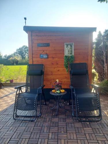 two chairs and a table in front of a cabin at Studio apartma Žirovnik in Cerklje na Gorenjskem