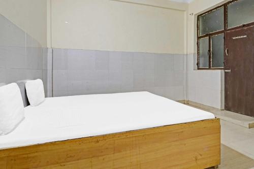 a bedroom with a bed with white sheets and a window at SPOT ON Hotel 7G in Dayāl Bāgh