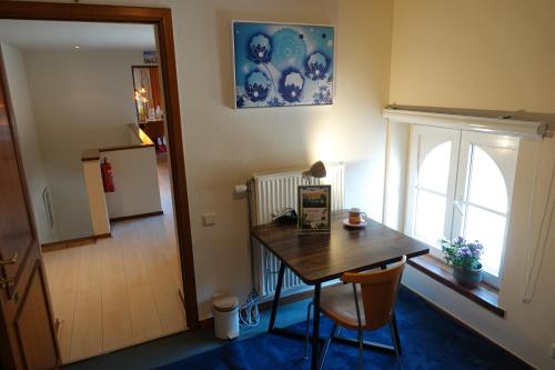 a dining room with a table and a window at Le Grand Jardin in Dalhem