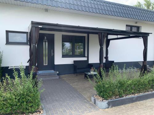 a detached house with a blue door and a patio at Paschlewwer Freizeit & Ferienhof in Köthen