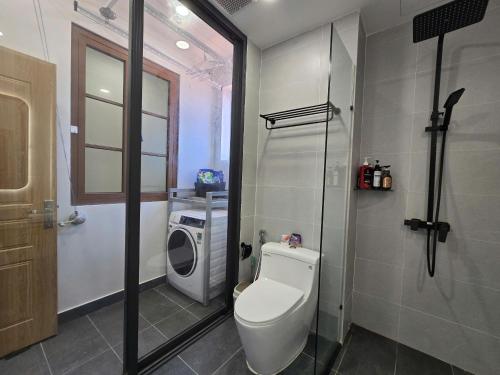 a bathroom with a toilet and a washing machine at Jana Hotel & Apartment - Firework & Aquatopia Water Park in Phu Quoc