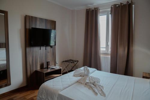 a bedroom with a bed with a tv on the wall at Hotel Ristorante La Rampina in Vimodrone