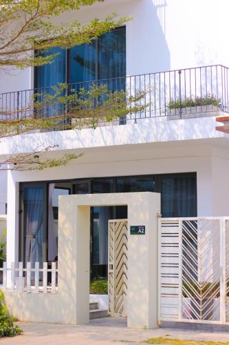 a white house with a balcony on top of it at Jades House Sầm Sơn in Sầm Sơn