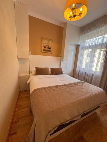 a bedroom with a large bed in front of a window at Broadway apartament in Šiauliai