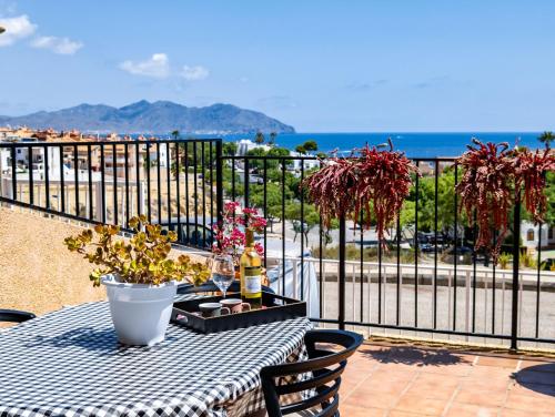 - une table avec une bouteille de vin sur le balcon dans l'établissement SunRise Den, a pie de playa, vista al mar y piscina, à El Alamillo