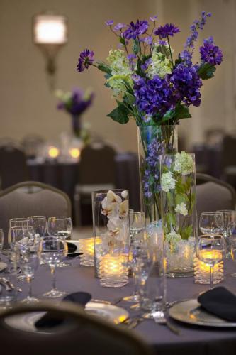 a table with a vase filled with purple and white flowers at Dallas-Addison Marriott Quorum by the Galleria in Addison