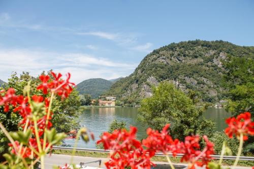 a view of a lake with mountains in the background at Hotel Grotto Bagat in Lavena Ponte Tresa