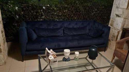 a living room with a blue couch and a glass table at Amphithea Luxury Apartment in Voroklini