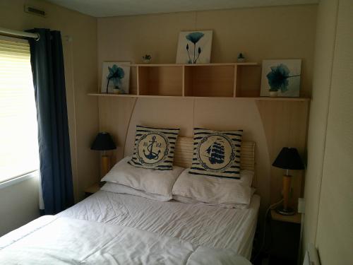 a bedroom with a bed with white sheets and pillows at 6 Berth on Golden Anchor (Cascade) in Chapel Saint Leonards
