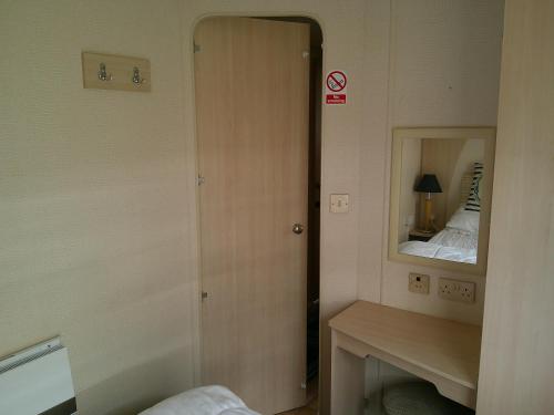 a small room with a mirror and a bed at 6 Berth on Golden Anchor (Cascade) in Chapel Saint Leonards
