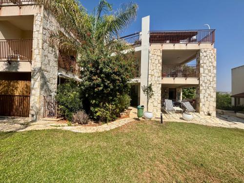 a house with a tree in front of a yard at Amphithea Luxury Apartment in Voroklini