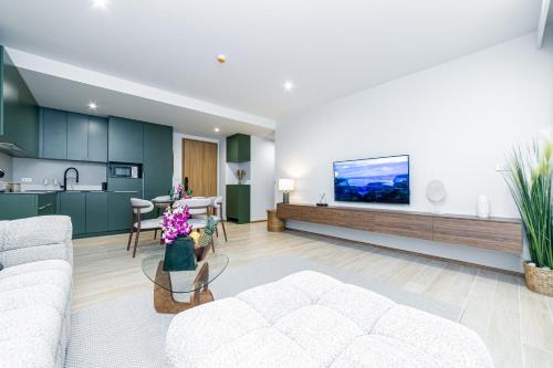 a living room with a white couch and a kitchen at Beachside 2 bedrooms apartment 200 meters to Bang Tao Beach Manage by OCEAN HUB in Bang Tao Beach