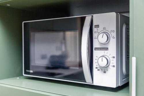 a microwave oven sitting on top of a shelf at Beachside 2 bedrooms apartment 200 meters to Bang Tao Beach Manage by OCEAN HUB in Bang Tao Beach