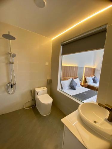 a bathroom with a toilet and a sink with a mirror at Khách sạn Thảo An in Phước Hậu (1)