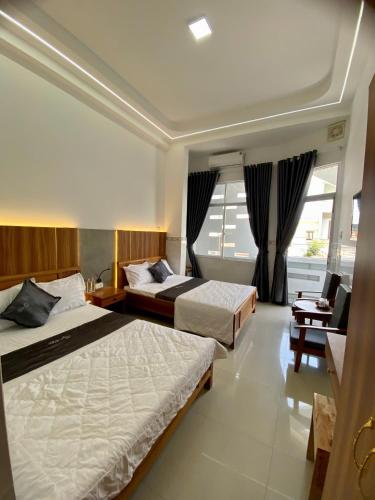a hotel room with two beds and a desk at Khách sạn Thảo An in Phước Hậu (1)