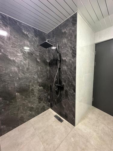 a bathroom with a shower with a black marble wall at Alvina Terrace in Tsaghkadzor