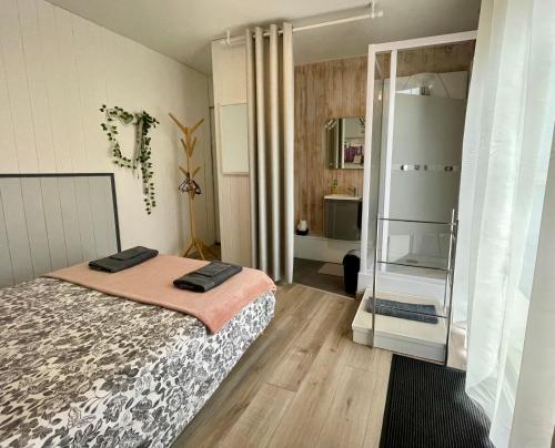 a small bedroom with a bed and a bathroom at Les chambres du Vallon in Chambretaud