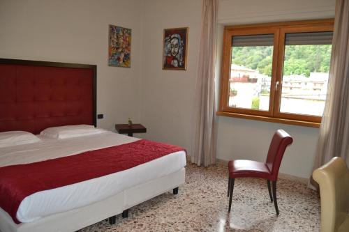 a bedroom with a bed and a chair and a window at Hotel Piazza Marconi in Cassino
