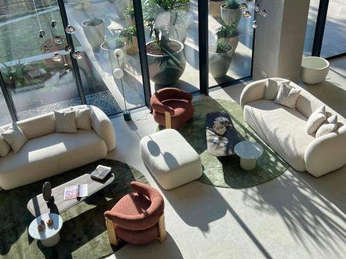 a living room with white couches and tables and windows at Hotel Sumratin in Dubrovnik