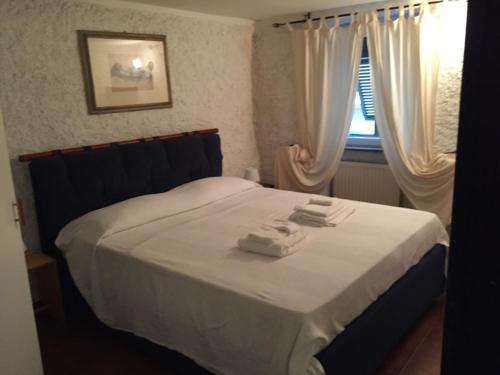 1 dormitorio con 1 cama con 2 toallas en My Holiday La Serra, en Lerici