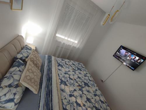 a small bedroom with a bed and a television at Stan na dan Paradiso in Lukavica