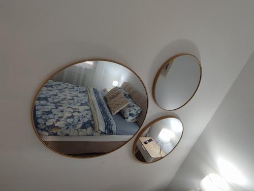 a mirror on a wall with a bed in a bedroom at Stan na dan Paradiso in Lukavica