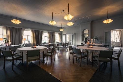 a dining room with tables and chairs and lights at Hotel Ranten in Falköping