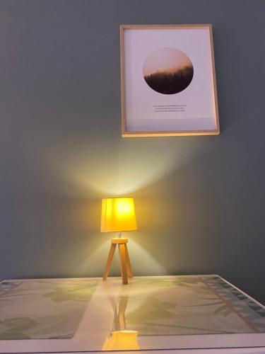 a lamp in a room with a picture on the wall at Le Refuge du Lac in Chaumousey