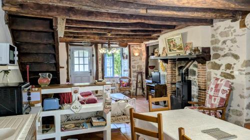 a living room with a table and a fireplace at La ferme des souvenirs in Vaulry