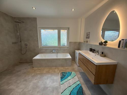 a large bathroom with a tub and a sink at Modern DesignApartment plus Garden 