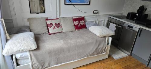 a bed with pillows on it in a kitchen at La Belle Époque Studio in Le Mont-Dore