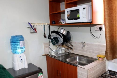 a small kitchen with a sink and a microwave at Milele studio bnb in Nakuru