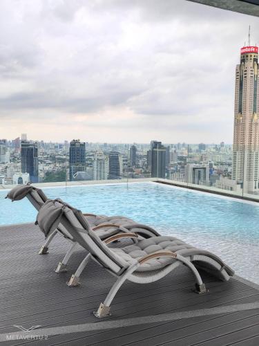 a lounge chair on the roof of a building with a pool at Brand New 2 bedroom near Paragon in Pratunam