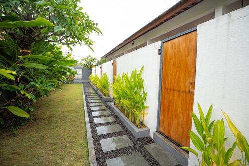 a walkway next to a house with plants at Abimanyu Guest House in Seminyak