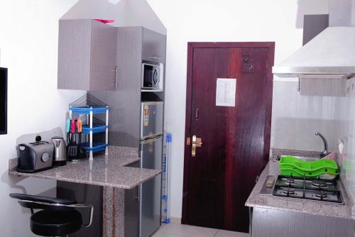 a small kitchen with a stove and a red door at Accra City Studios & Apartment in Accra