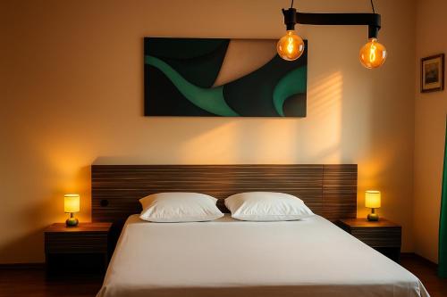 1 dormitorio con 1 cama con 2 almohadas y 2 lámparas en Obilic L Apartment, en Belgrado
