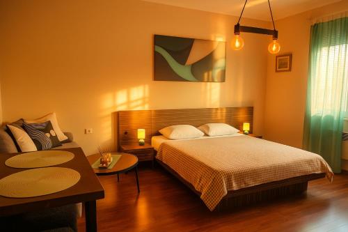 a bedroom with a large bed and a couch at Obilic L - City View apartment in Pedestrian Zone in Belgrade
