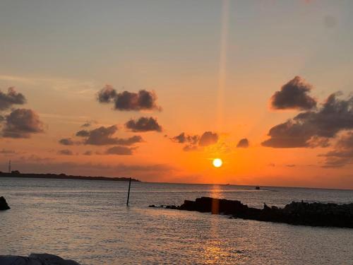 a sunset over the ocean with the sun setting at Fiya Inn in Maalhos
