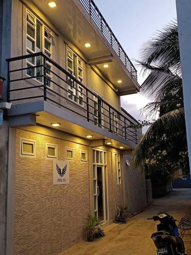 a building with a balcony on the side of it at Fiya Inn in Maalhos