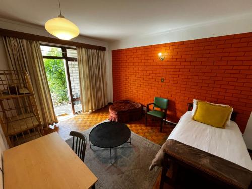 a bedroom with a bed and a brick wall at Retro City Center Gem by ARPA Hospitalities in Stellenbosch