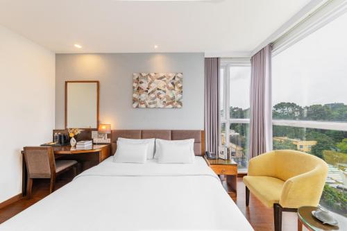pokój hotelowy z łóżkiem, biurkiem i oknem w obiekcie A25 Hotel - 55 Cách Mạng Tháng 8 w Ho Chi Minh